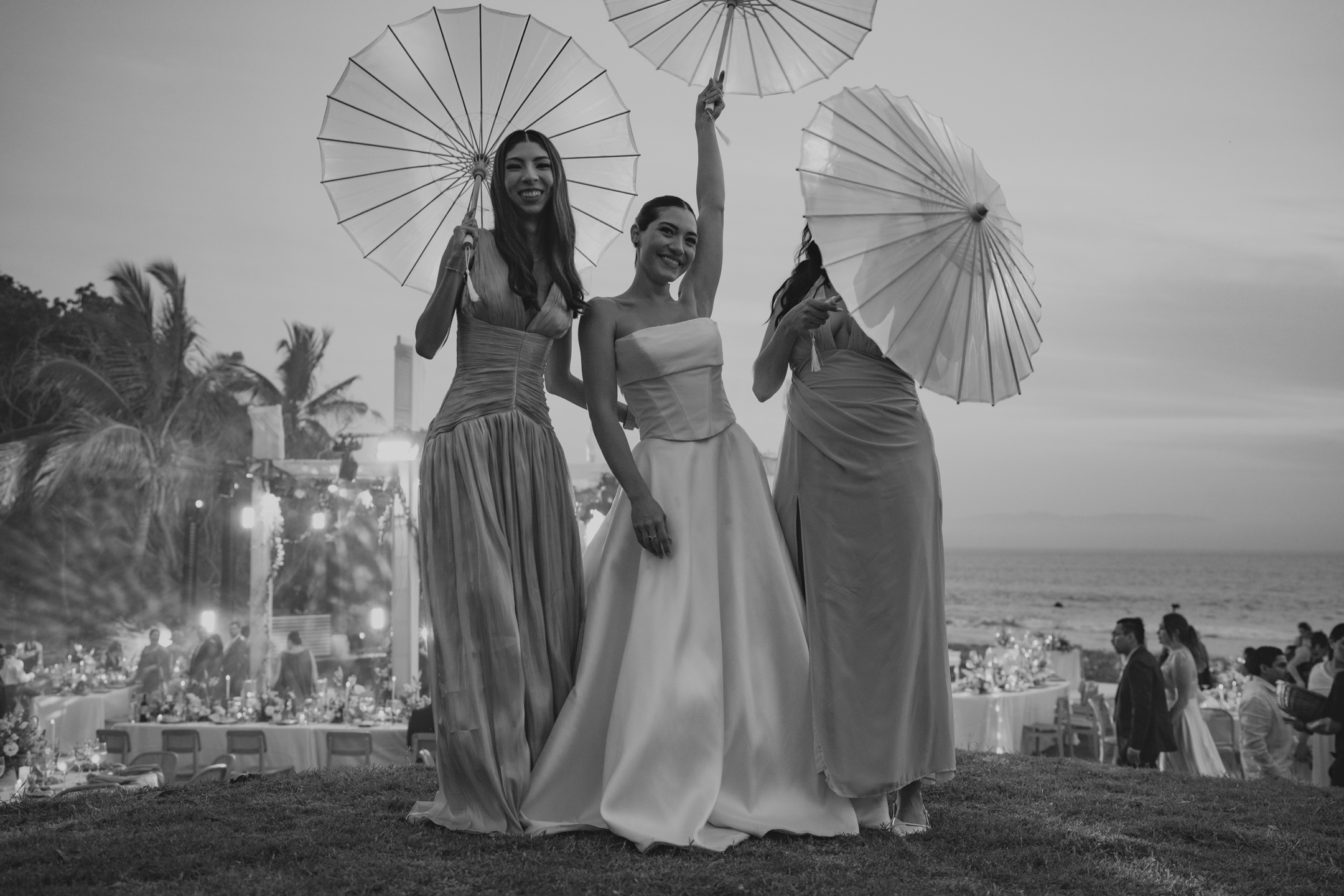 Bride and bridesmaids with parasols at dusk, black and white